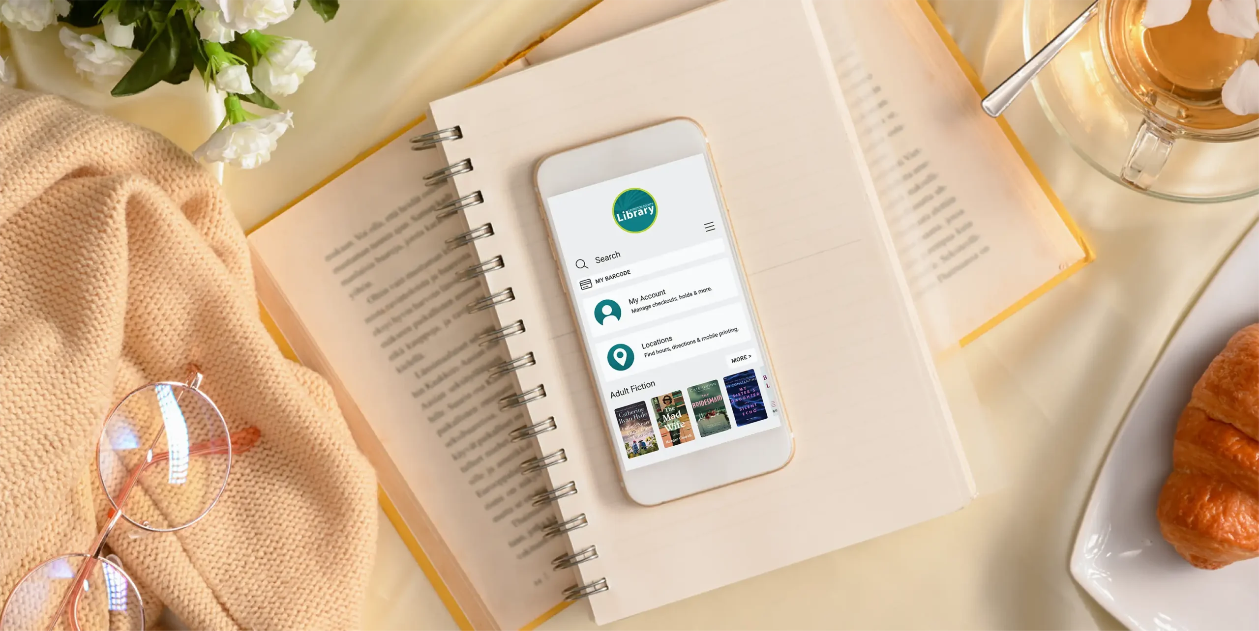 Phone displaying LexCoLibrary app homescreen on a notepad