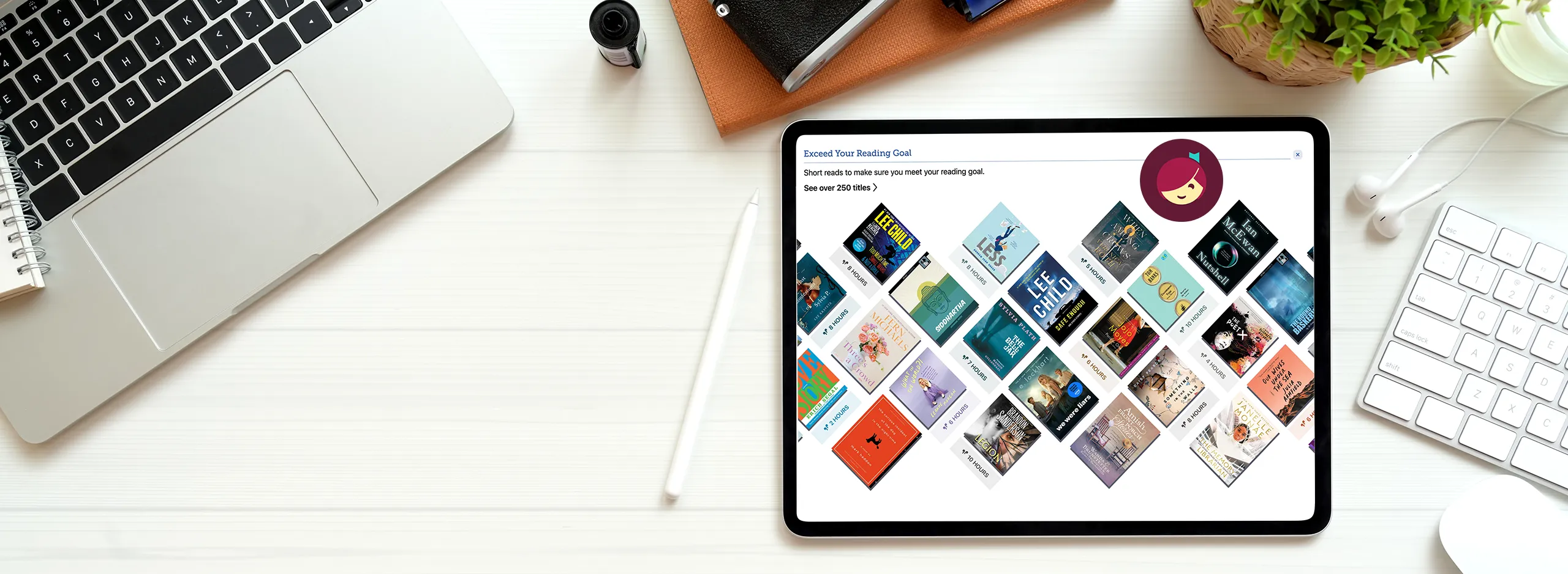 (banner) apple mac laptop computer, iPad with image of book titles on hoopla digital, keyboard, leather notebook and plant